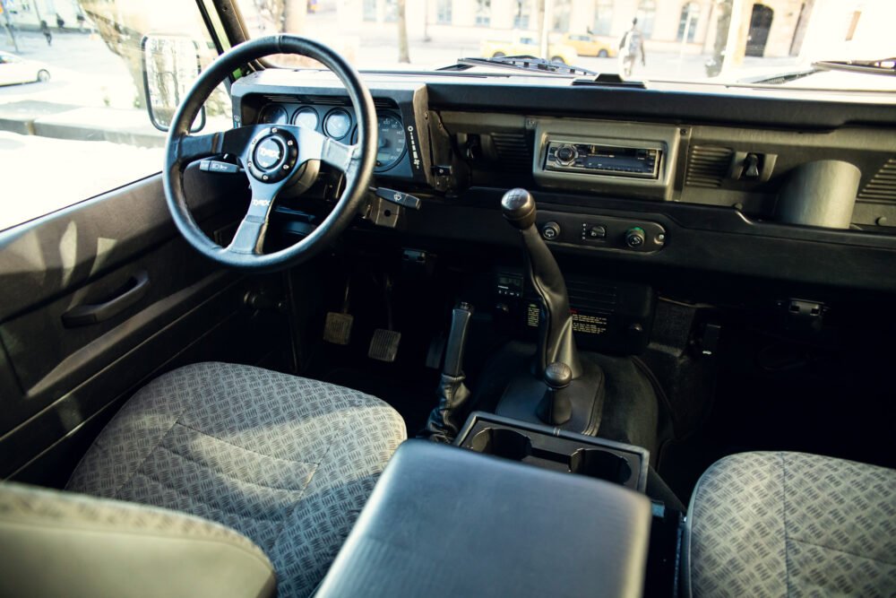 Vintage car interior with steering wheel and dashboard.