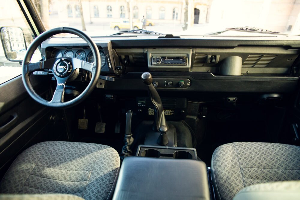 Vintage car interior with steering wheel and dashboard.