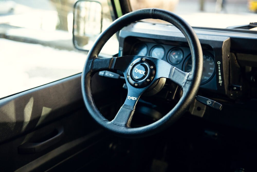 Close-up of modern vehicle steering wheel and dashboard.