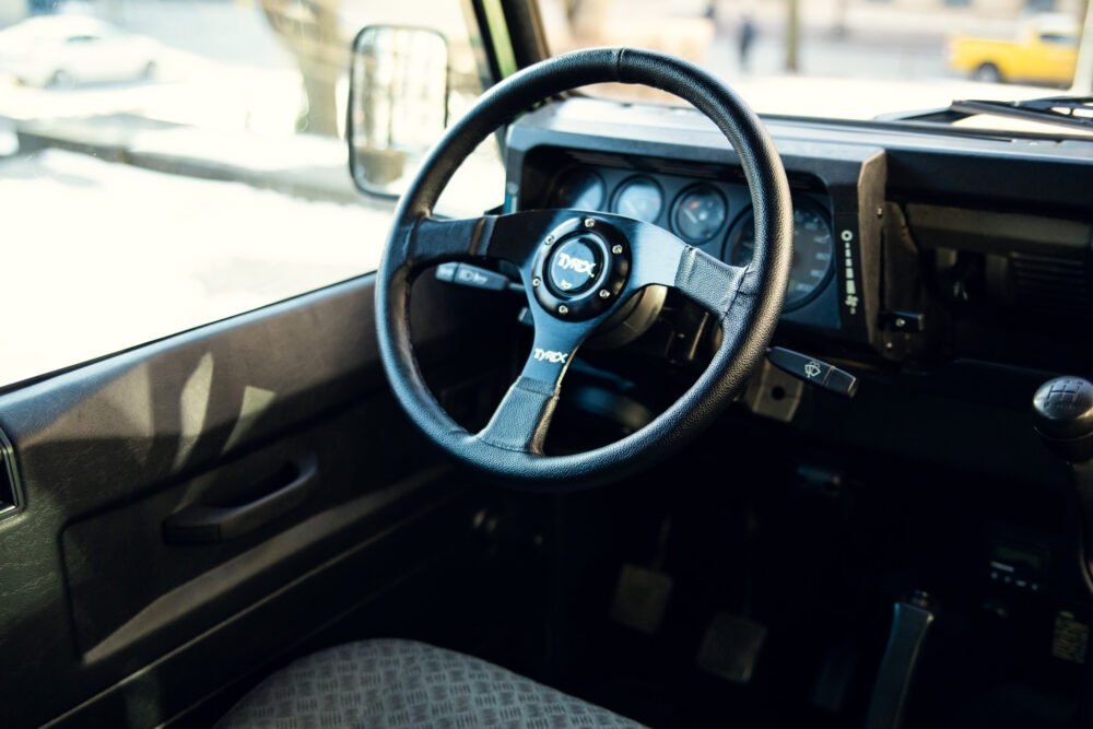 Interior of a car showing steering wheel and dashboard.