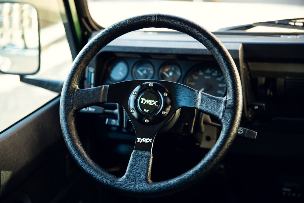 Black steering wheel inside modern vehicle dashboard.