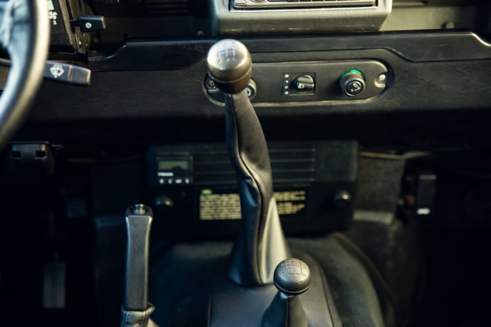 Vintage car's manual gearshift and dashboard close-up.