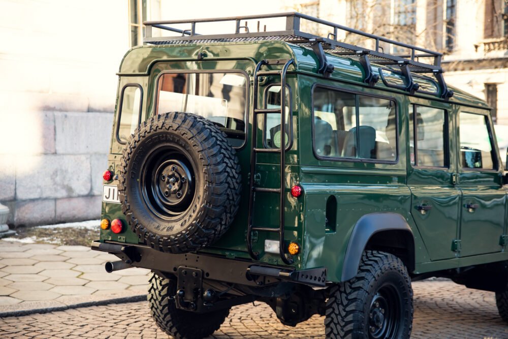 Green vintage off-road vehicle parked in city.