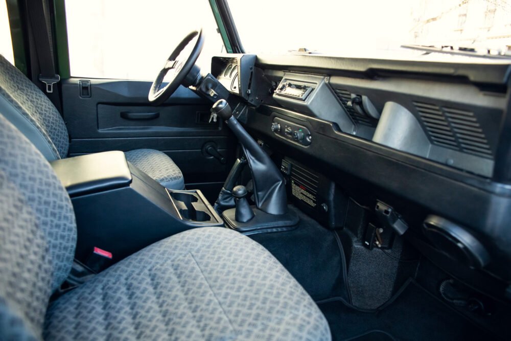 Vintage car interior with dashboard and manual transmission.