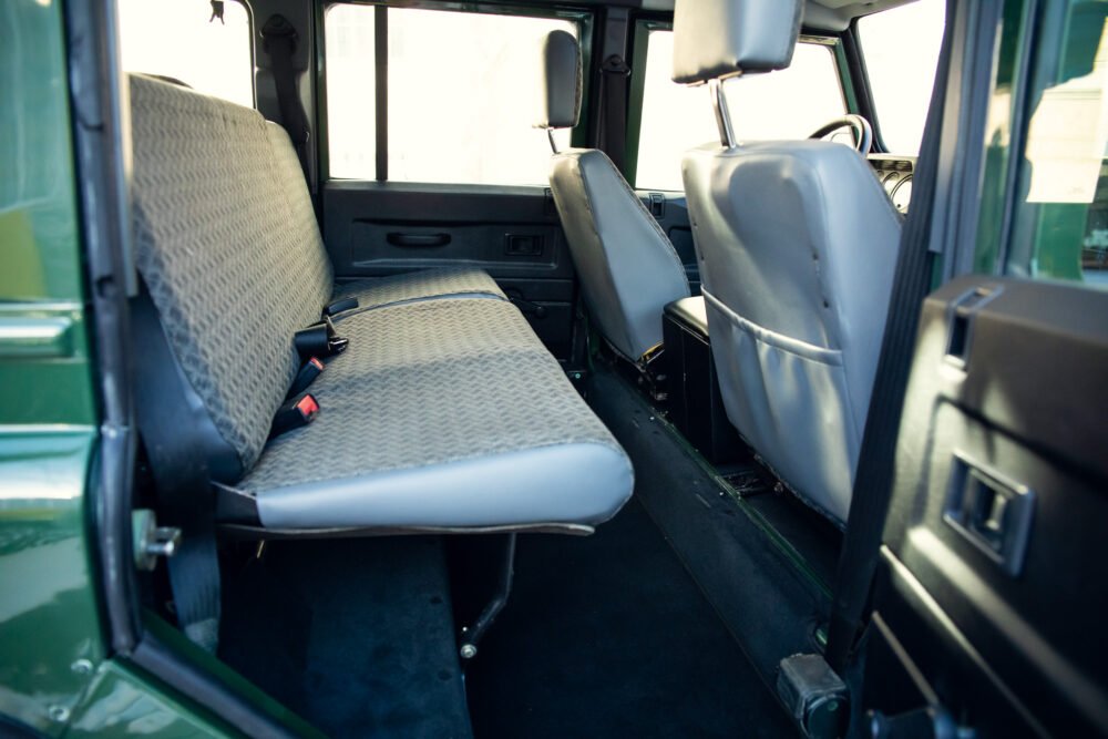 Interior of empty vehicle showing bench seats and doors.