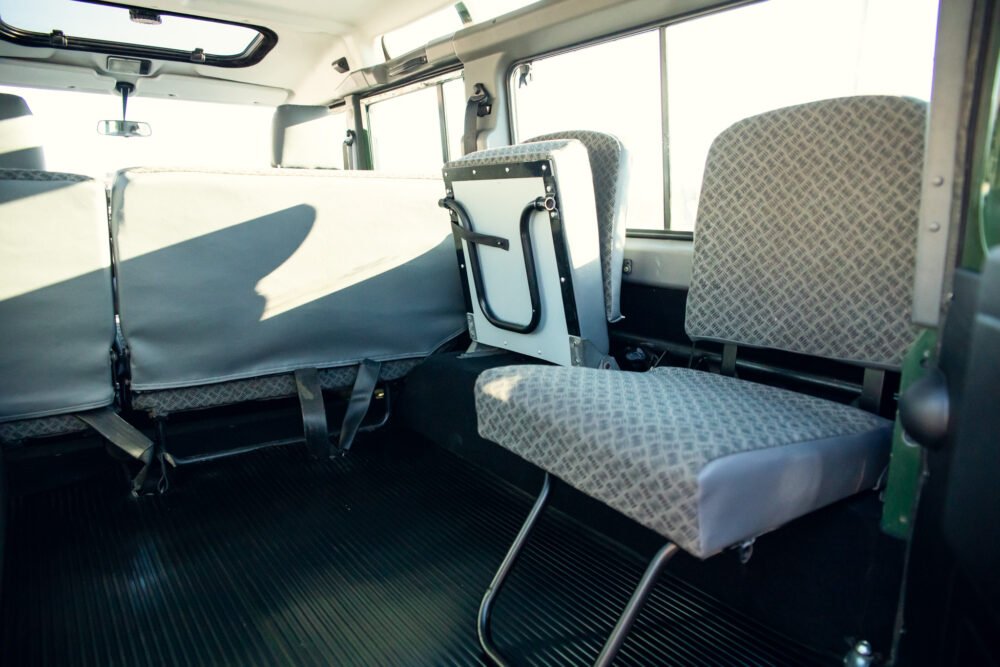 Interior of an empty, sunlit shuttle bus.