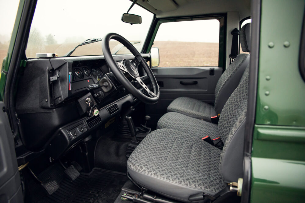 Interior of vintage green SUV with patterned seats.