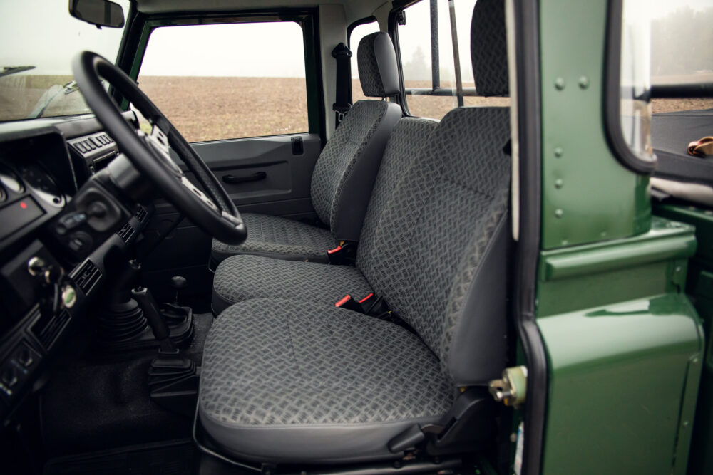 Interior of green cab with patterned seats and steering wheel.