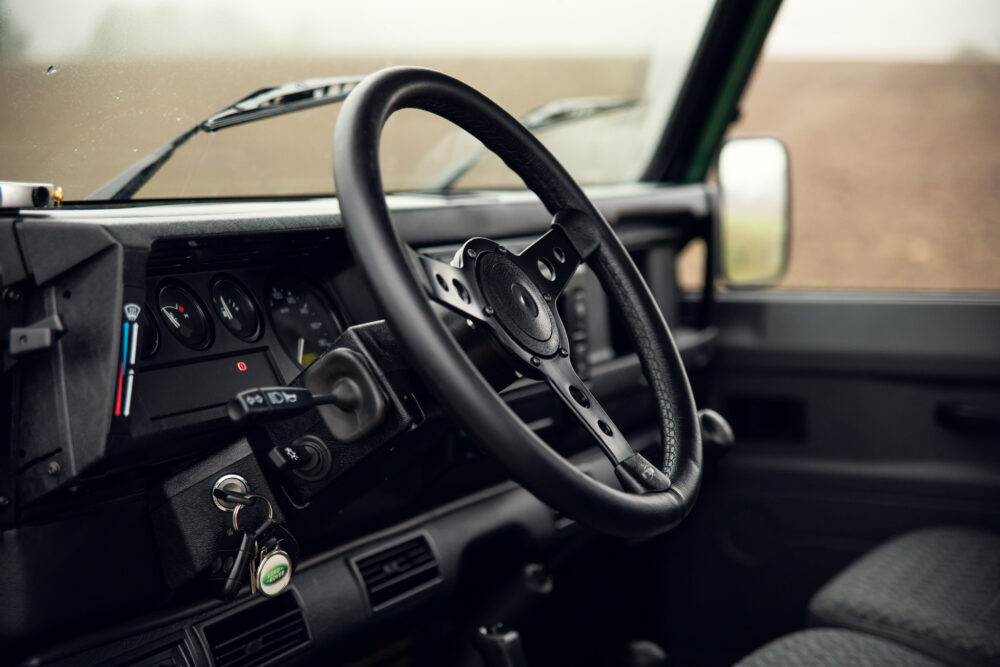 Vintage car dashboard and steering wheel, close-up view.