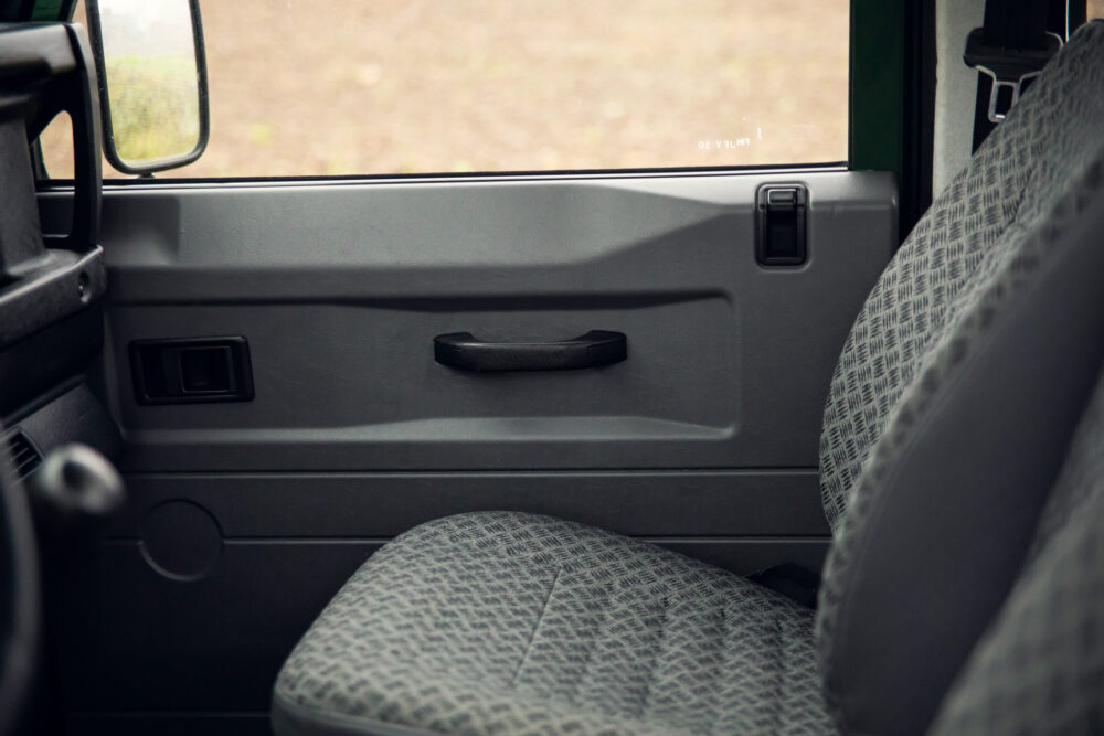 Interior view of a vehicle's passenger door and seat.