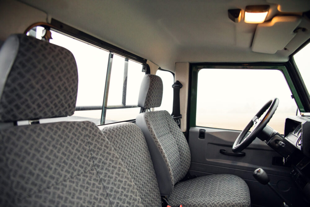 Interior of a vehicle showing seats and steering wheel.