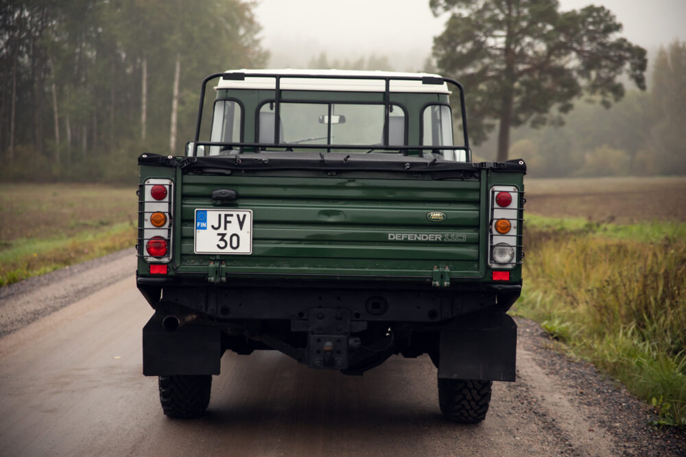 Green Land Rover Defender on foggy road