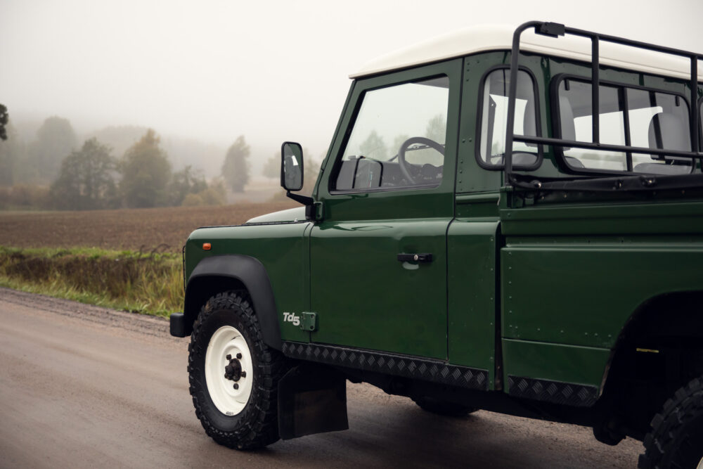 Green off-road vehicle on foggy country road.