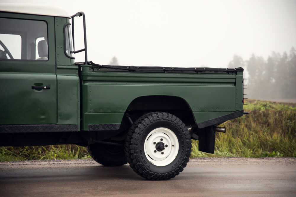 Green vintage pickup truck on foggy road.