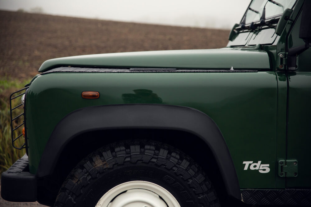 Green Land Rover Td5 close-up, off-road tires.