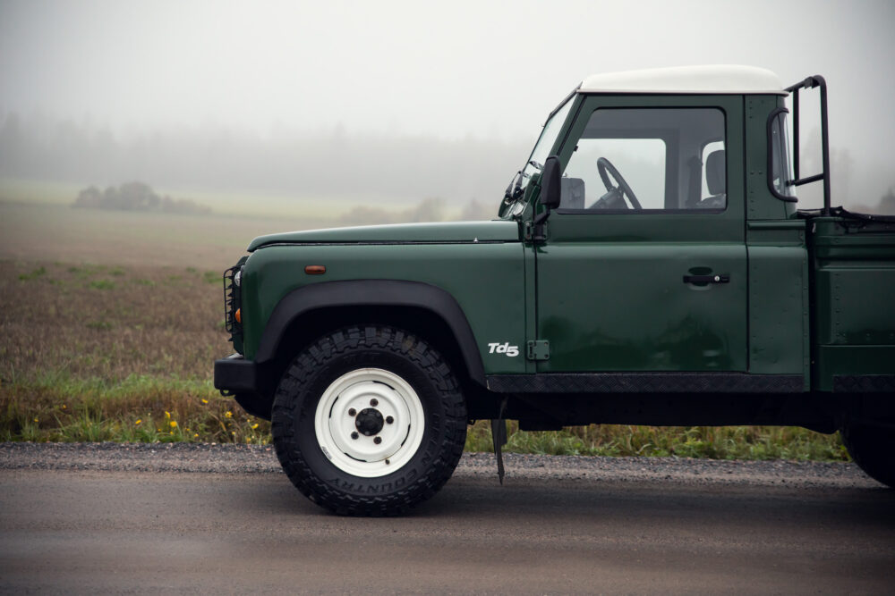 Green pickup truck on misty road.