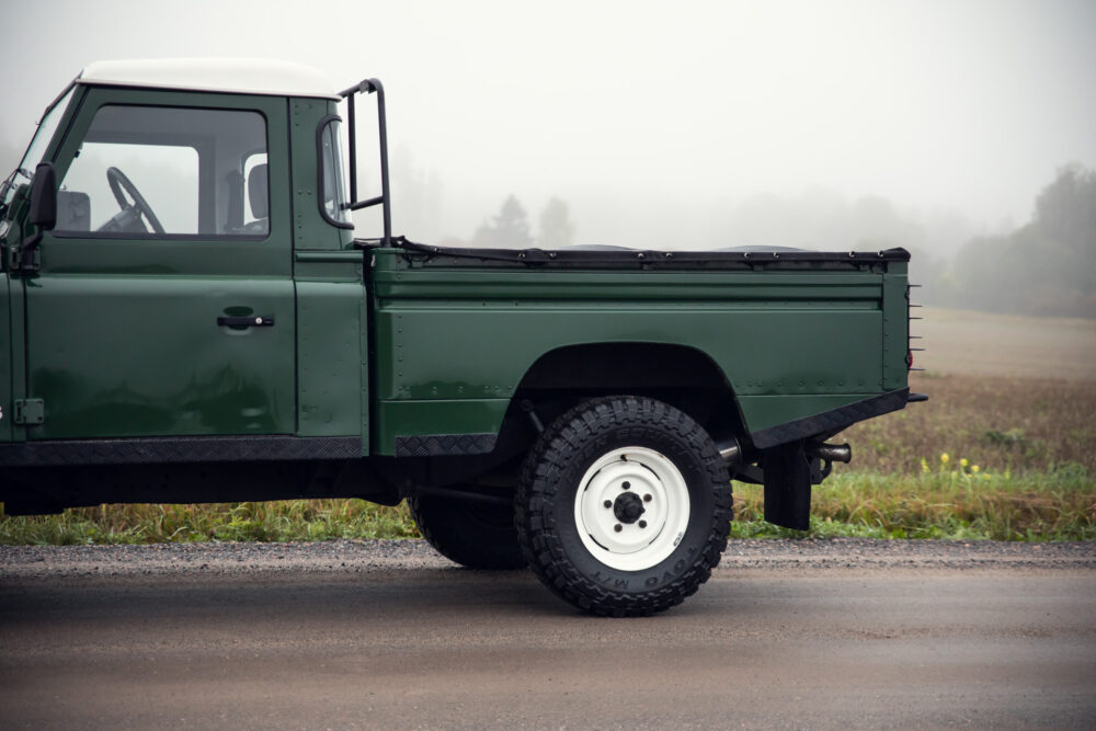 Green pickup truck on foggy road.