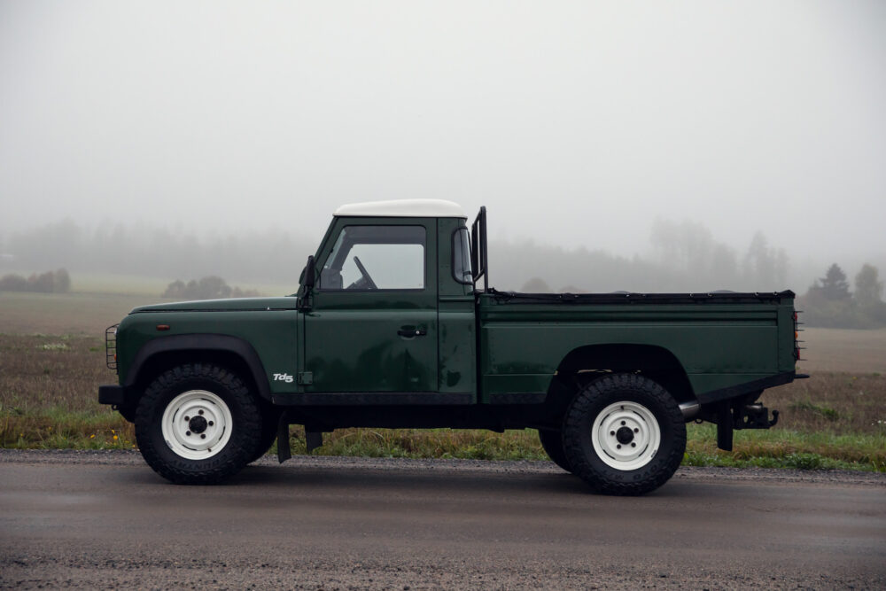 Green pickup truck on foggy road.