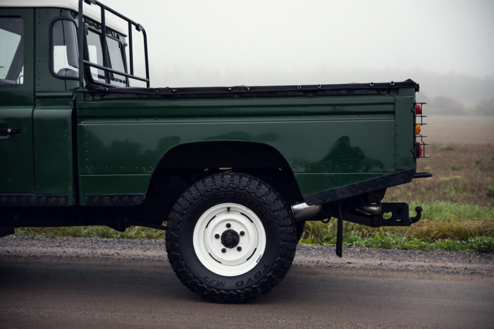 Green pickup truck on misty country road.