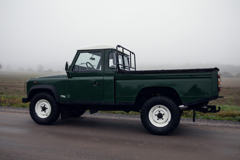 Green pickup truck in foggy rural setting.