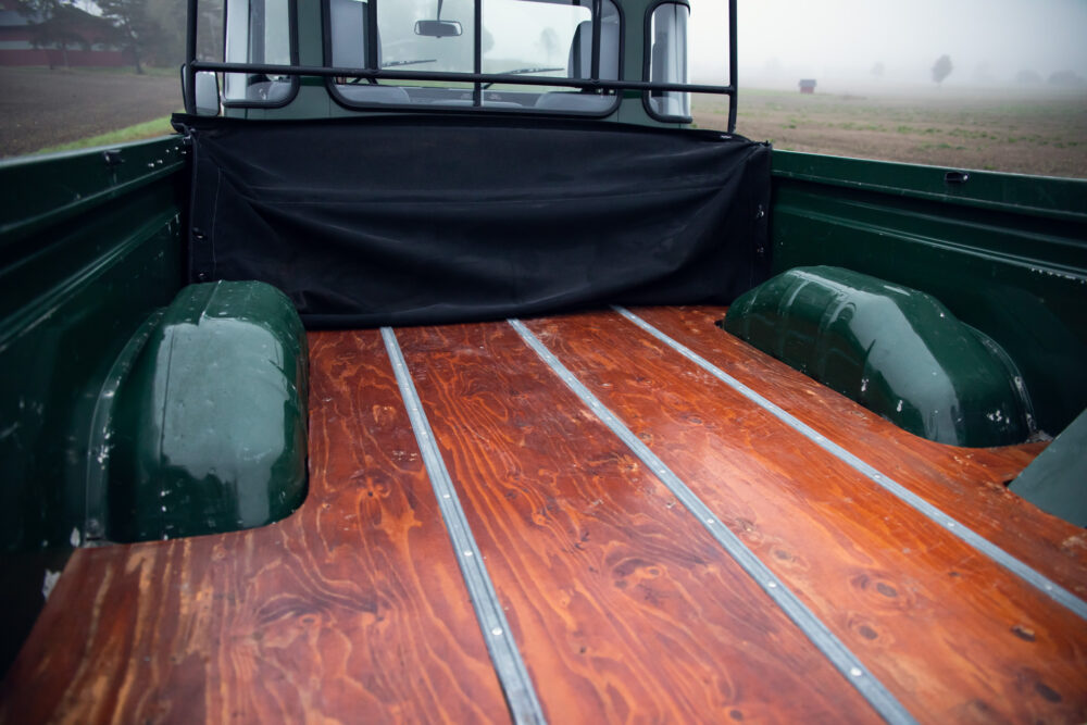 Polished wooden truck bed in misty rural setting.