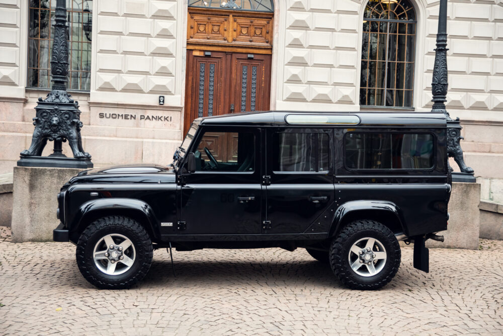 Black SUV parked outside historic building.