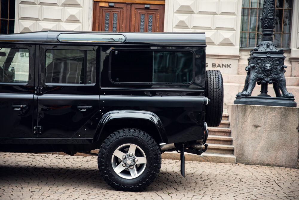 Black SUV parked near ornate street lamp and building.