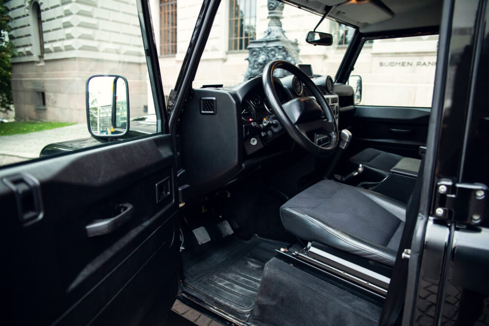 Interior view of an open door black SUV.