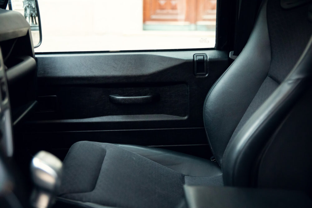 Interior view of car passenger door and seat.