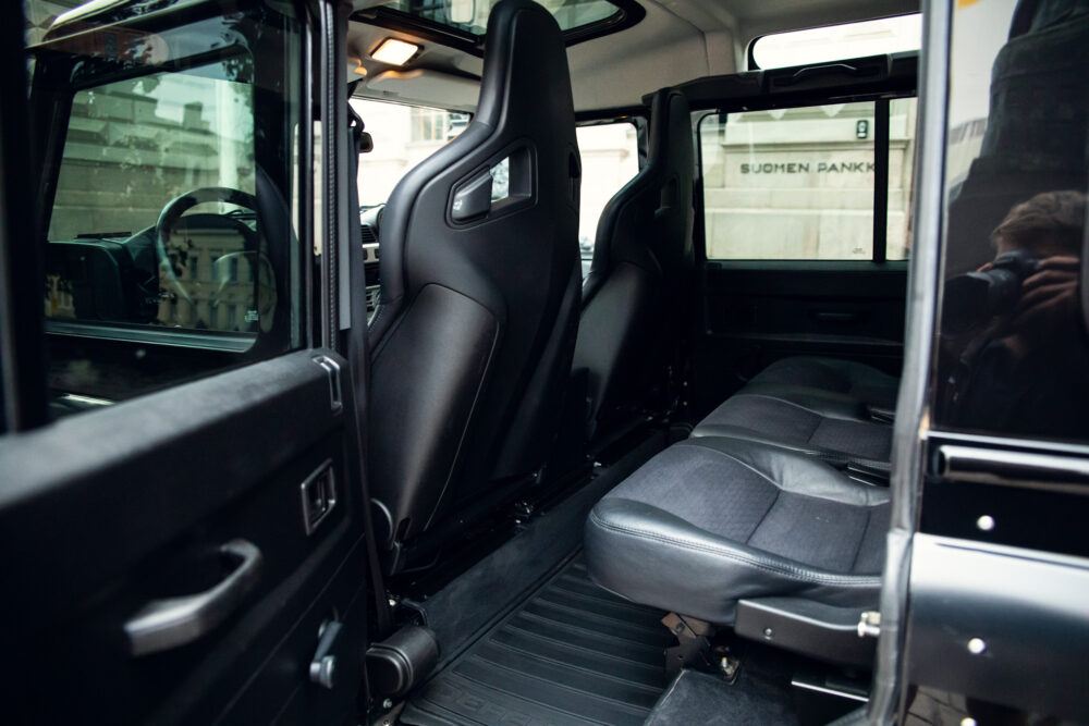 Interior of modern black vehicle with open door.