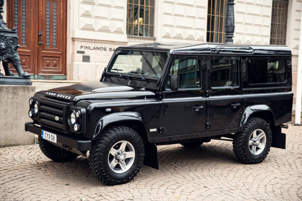 Black Land Rover Defender parked in city.