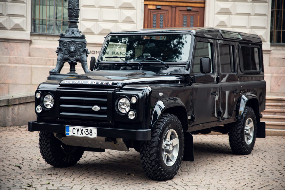 Black Land Rover Defender parked in urban setting.