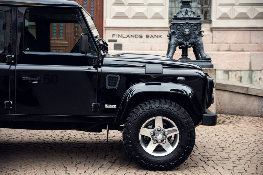 Black SUV parked near Finland's Bank statue.