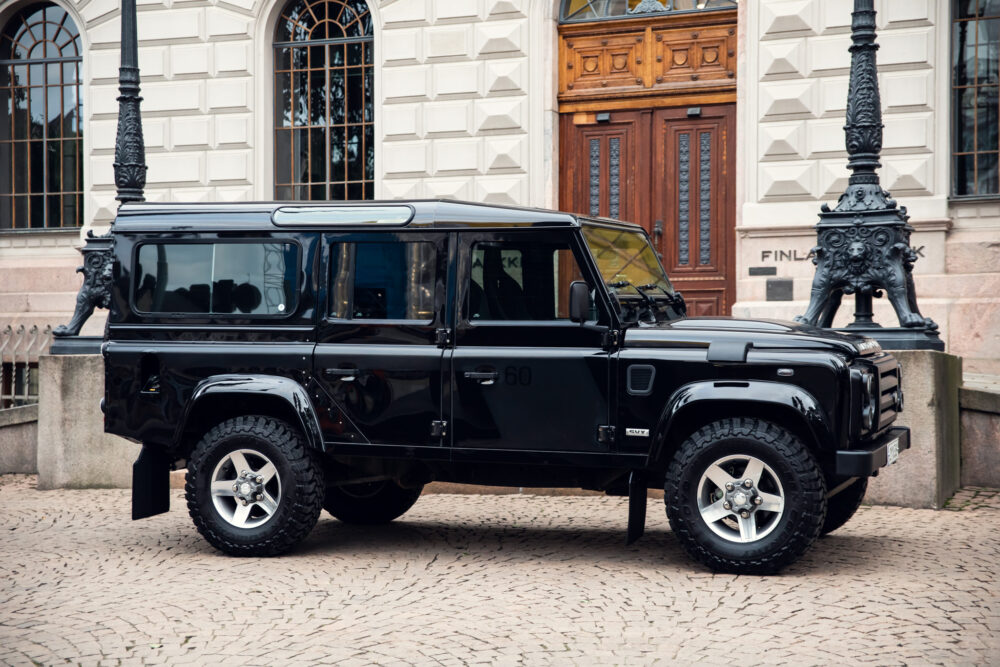 Black SUV parked near ornate street lamp and building.