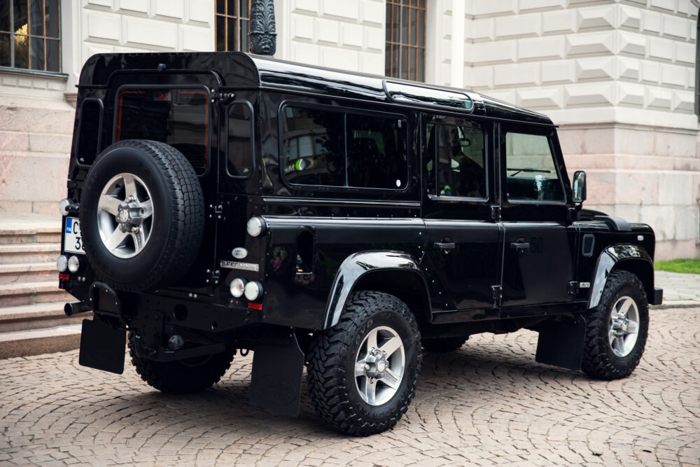 Black SUV parked near historical building.