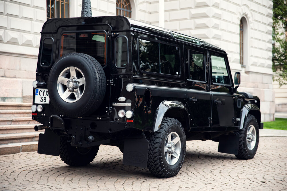 Black Land Rover Defender parked outside a building.