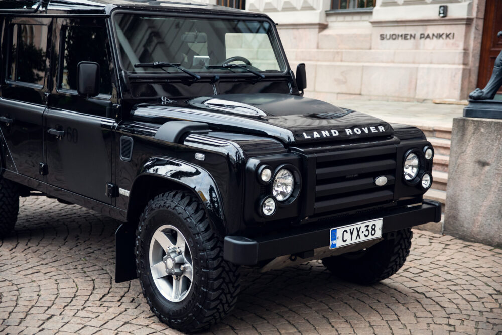 Black Land Rover Defender parked in urban setting.