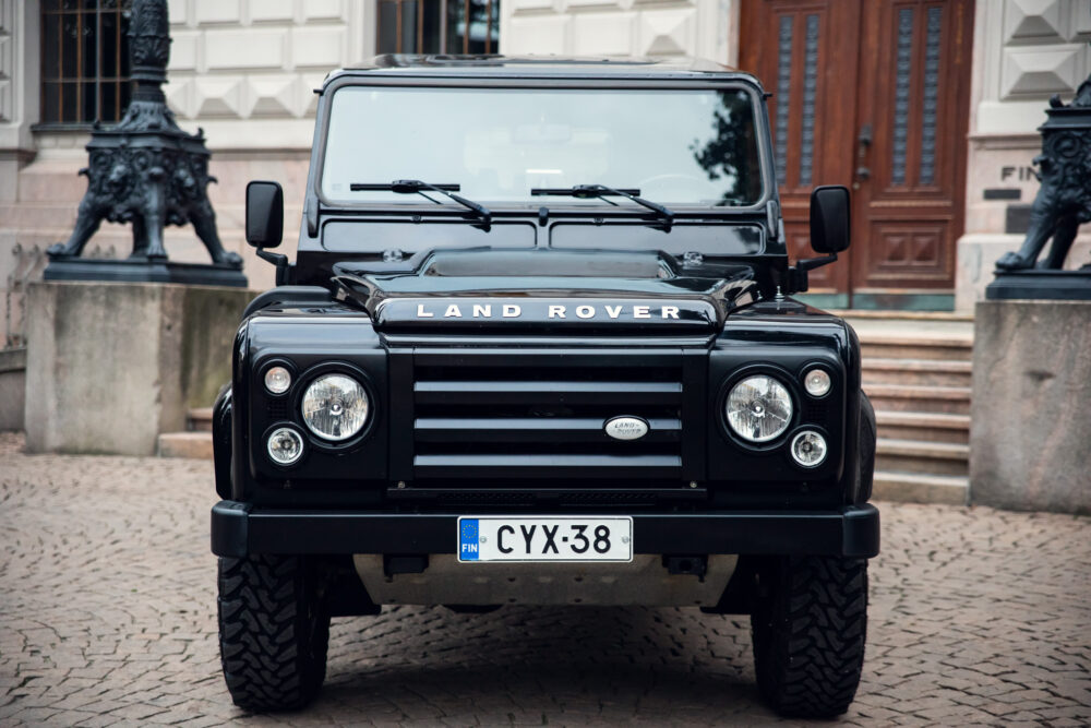 Black Land Rover Defender parked in urban setting.