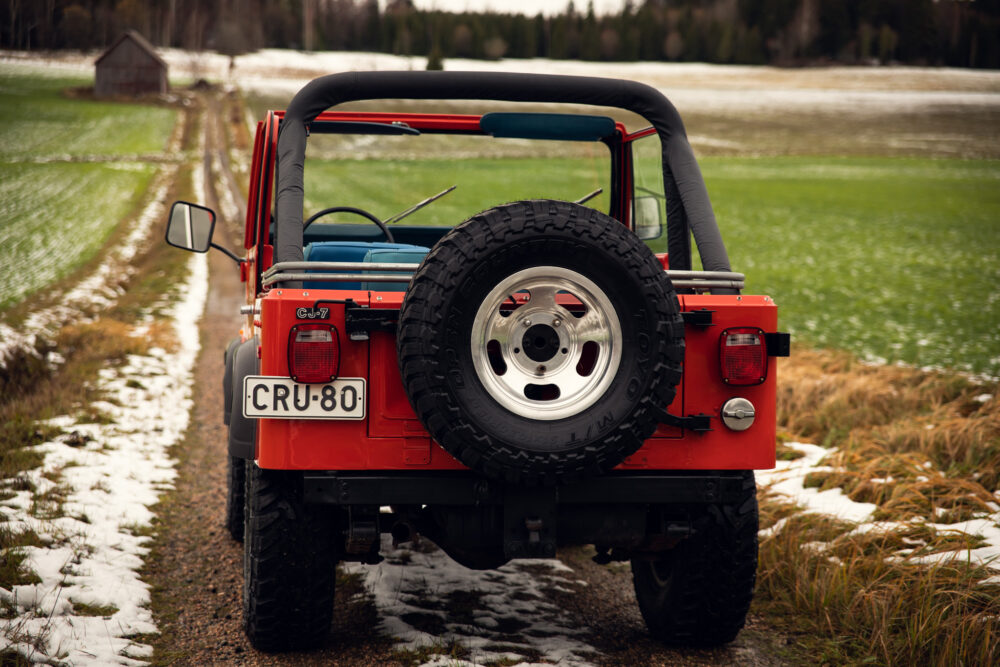 Red Jeep parked on snowy country road