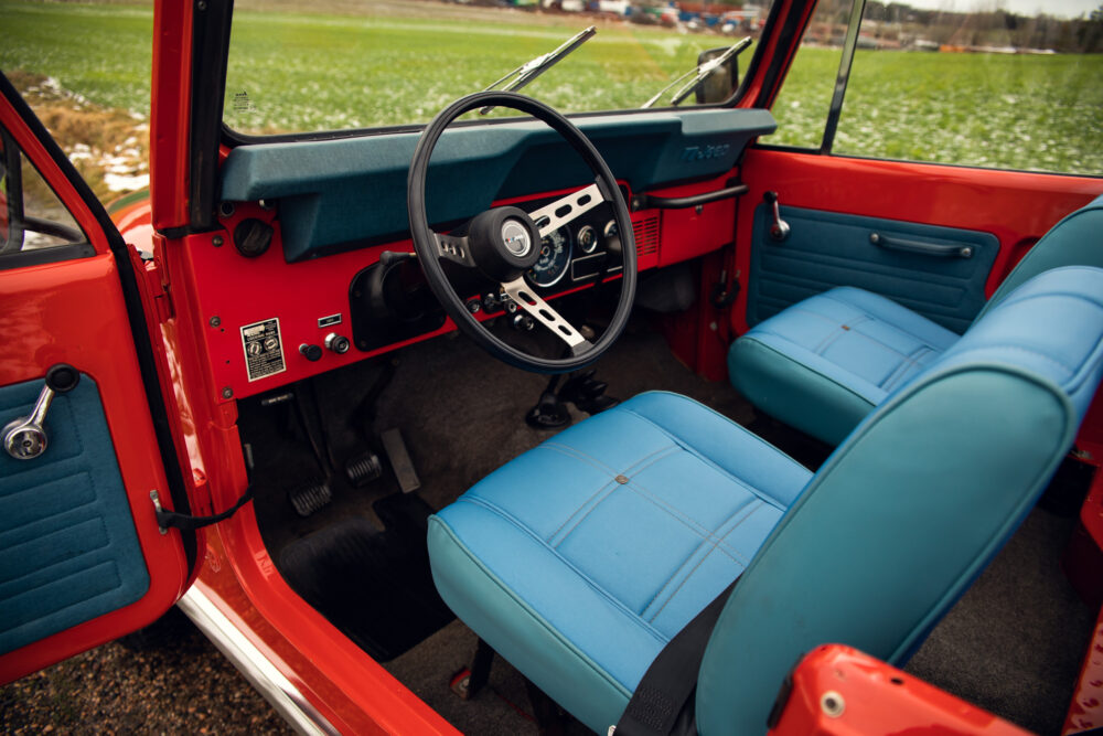 Vibrant red vintage car with stylish teal interior.