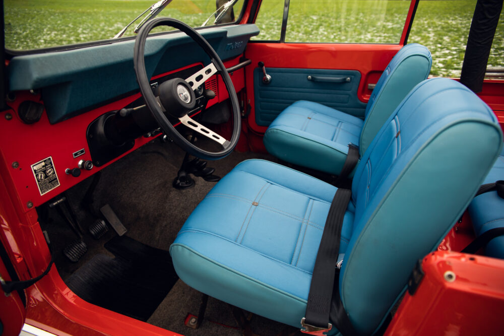 Vintage red vehicle interior with blue seats and dashboard