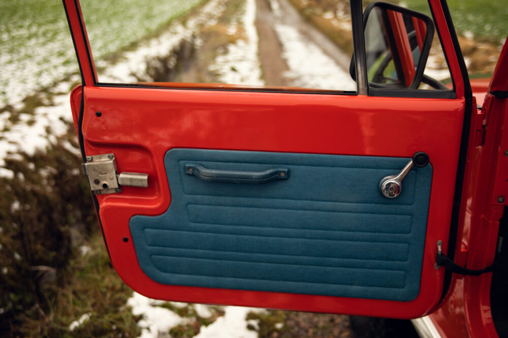 Red car door open showing blue interior panel