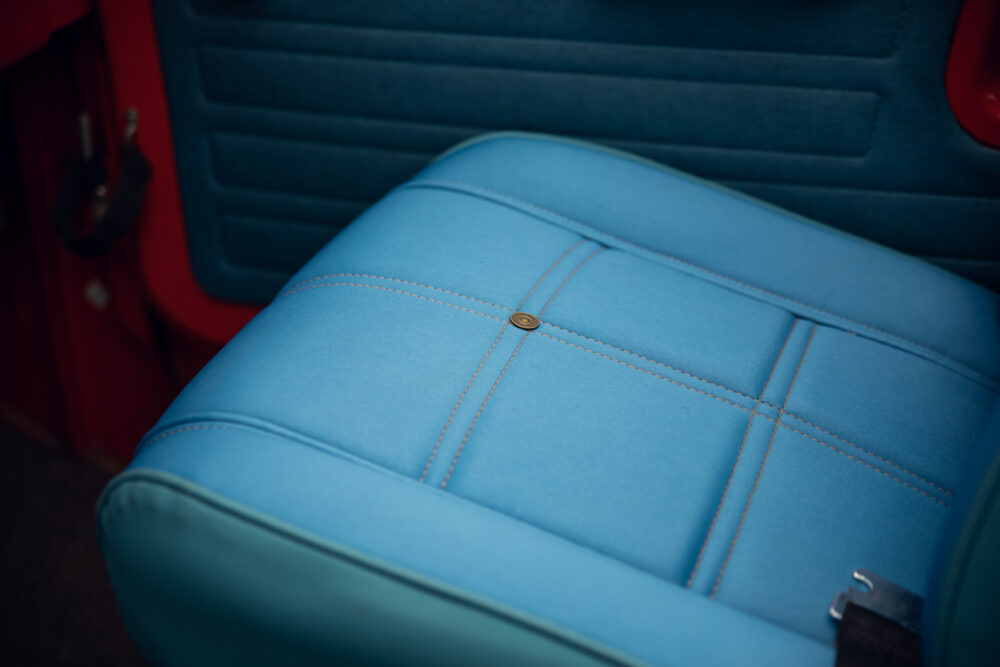 Blue vintage car seat with orange stitching detail