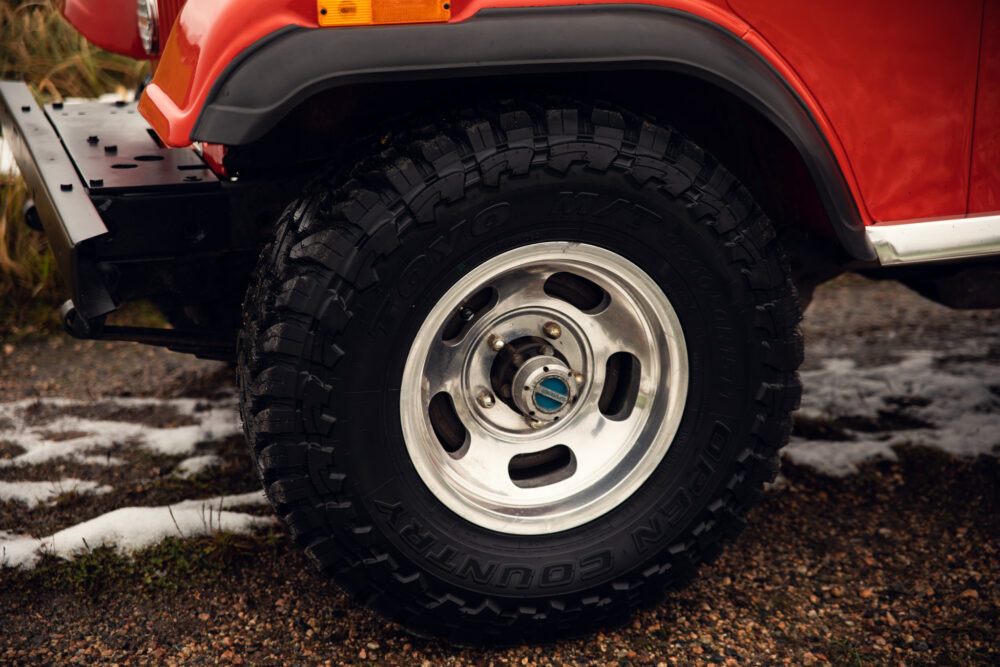 Close-up of red SUV's wheel on snowy ground