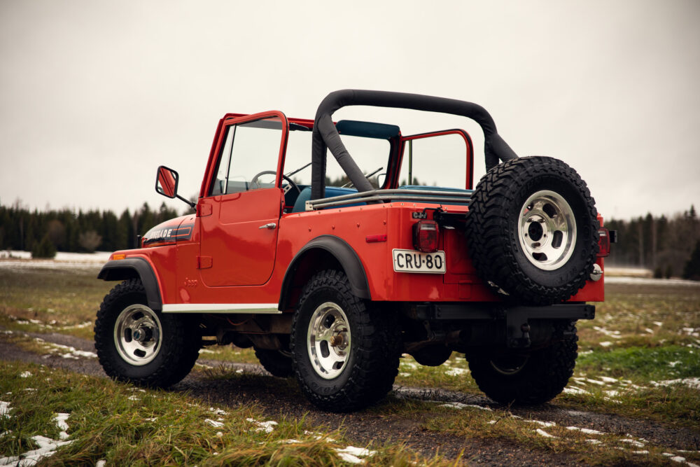 Vintage red jeep on snowy grassland