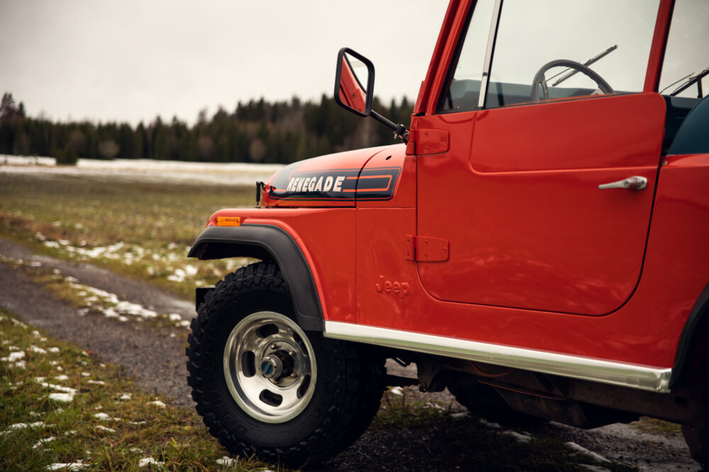 Red Jeep Renegade parked in snowy field