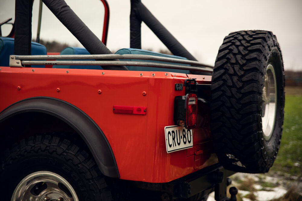 Rear view of red Jeep with spare tire