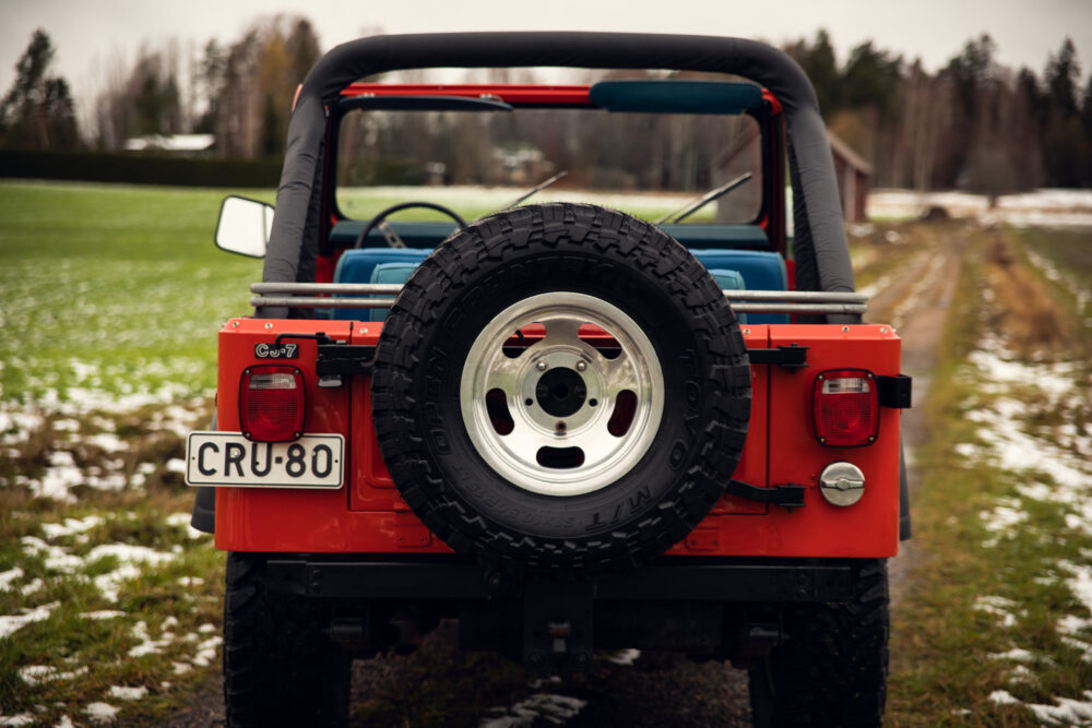 Red Jeep with spare tire on snowy field