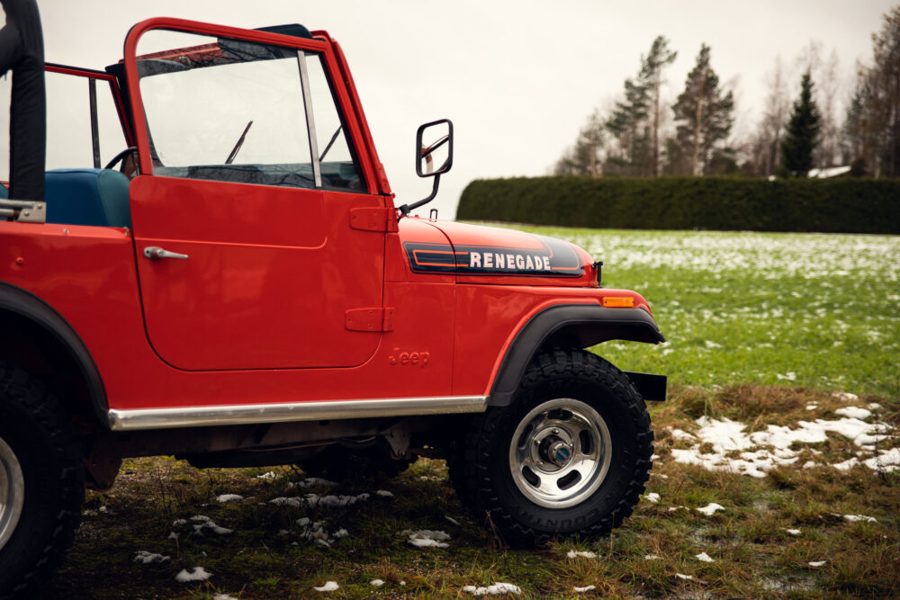 Red Jeep Renegade parked in snowy field