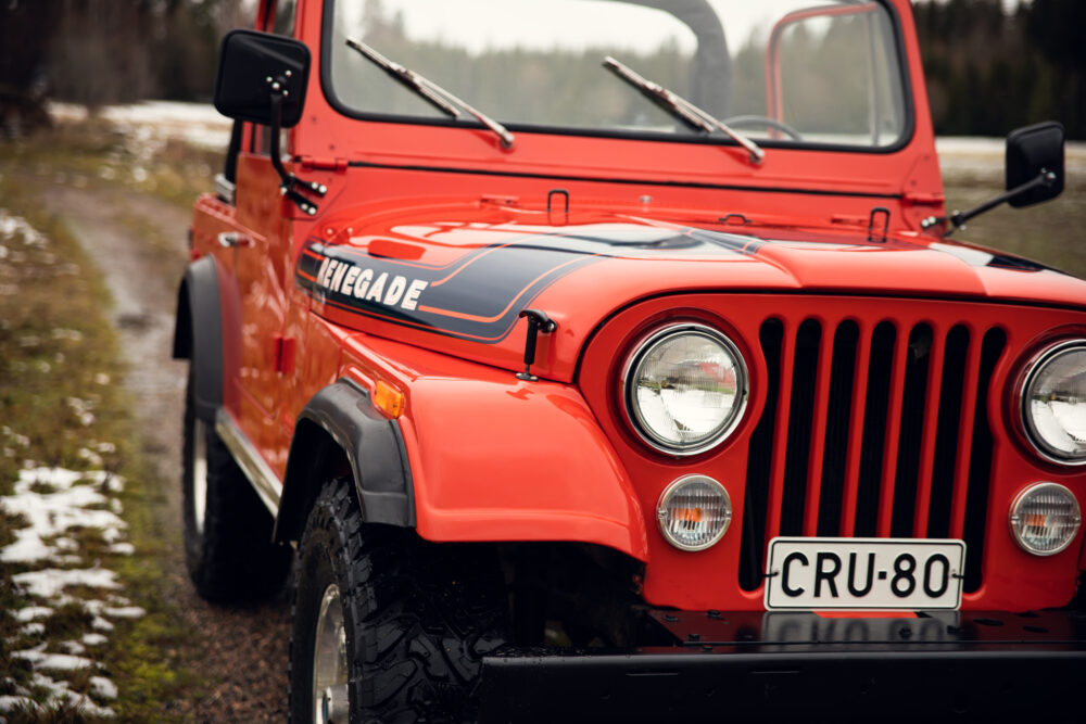 Red Jeep Renegade on a forest road